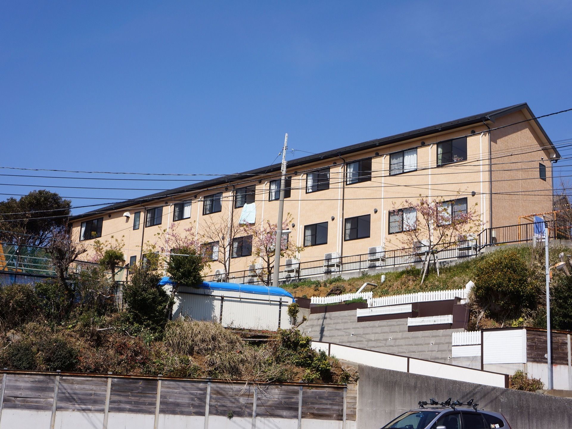 黒い三角の屋根の下に、部屋の窓が横長に並んでいる２階建ての建物である。少し高台の部分に建っているため、周りが良く見える。