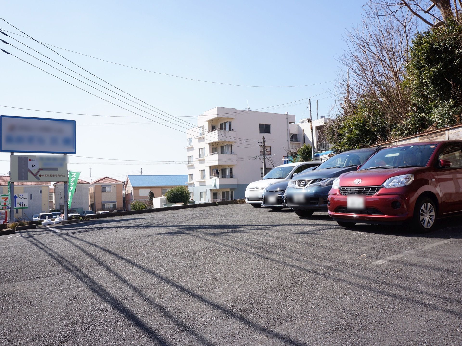 施設の敷地内には、広々とした駐車場が設けられている。施設名と概略図が記された大きな看板が設置されている。
