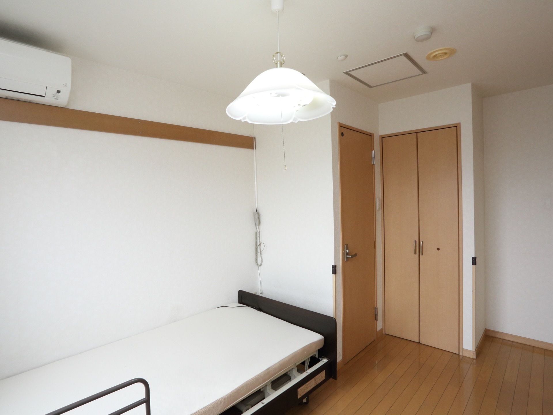 介護ベッド、エアコンが設置してある。トイレ、クローゼットが備えつけられている。床はフローリングである。