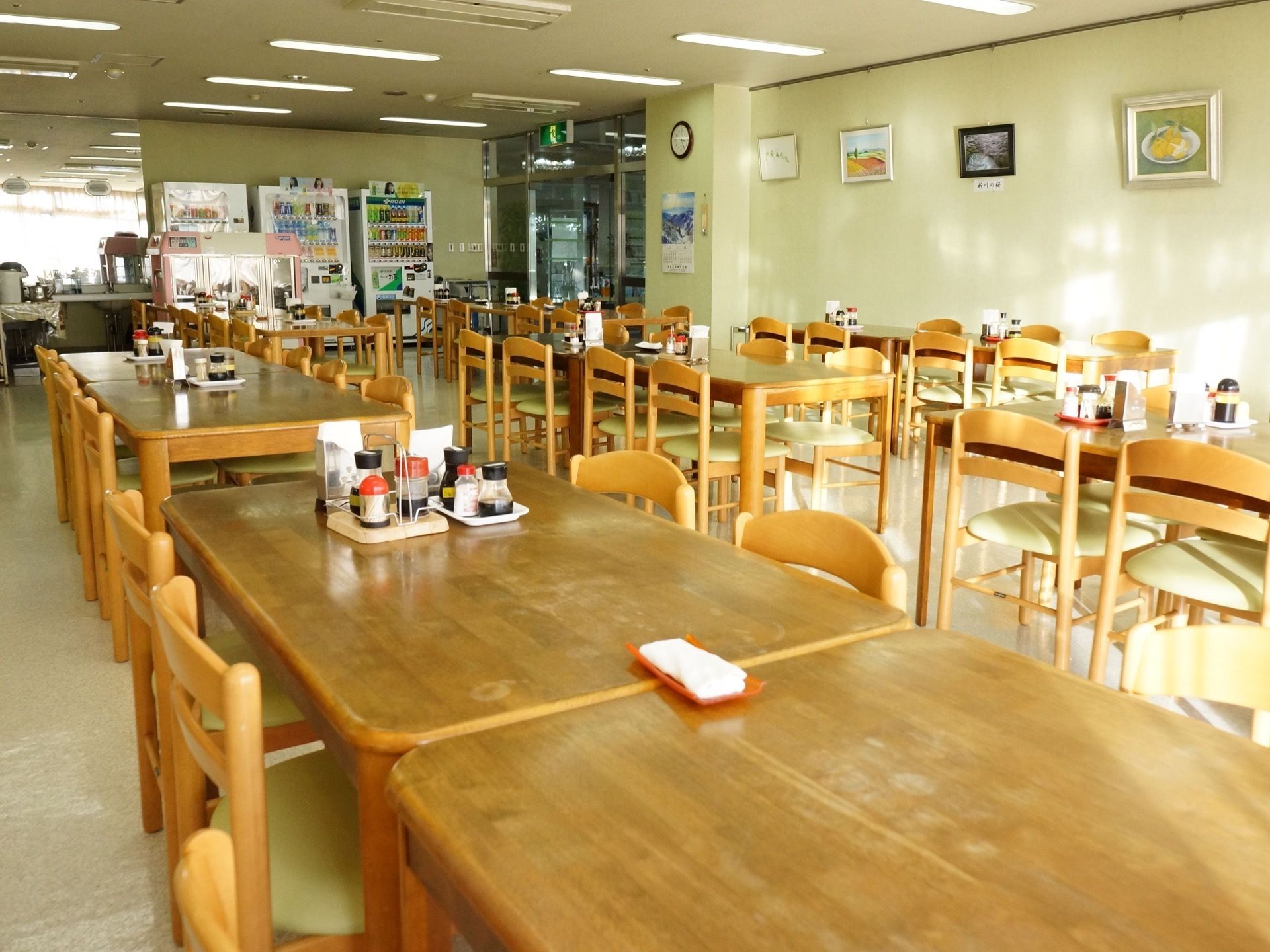 食堂のとびらはガラスで両開きになっている。天井には誘導灯がついている。すぐ右に自動販売機が設置してある。