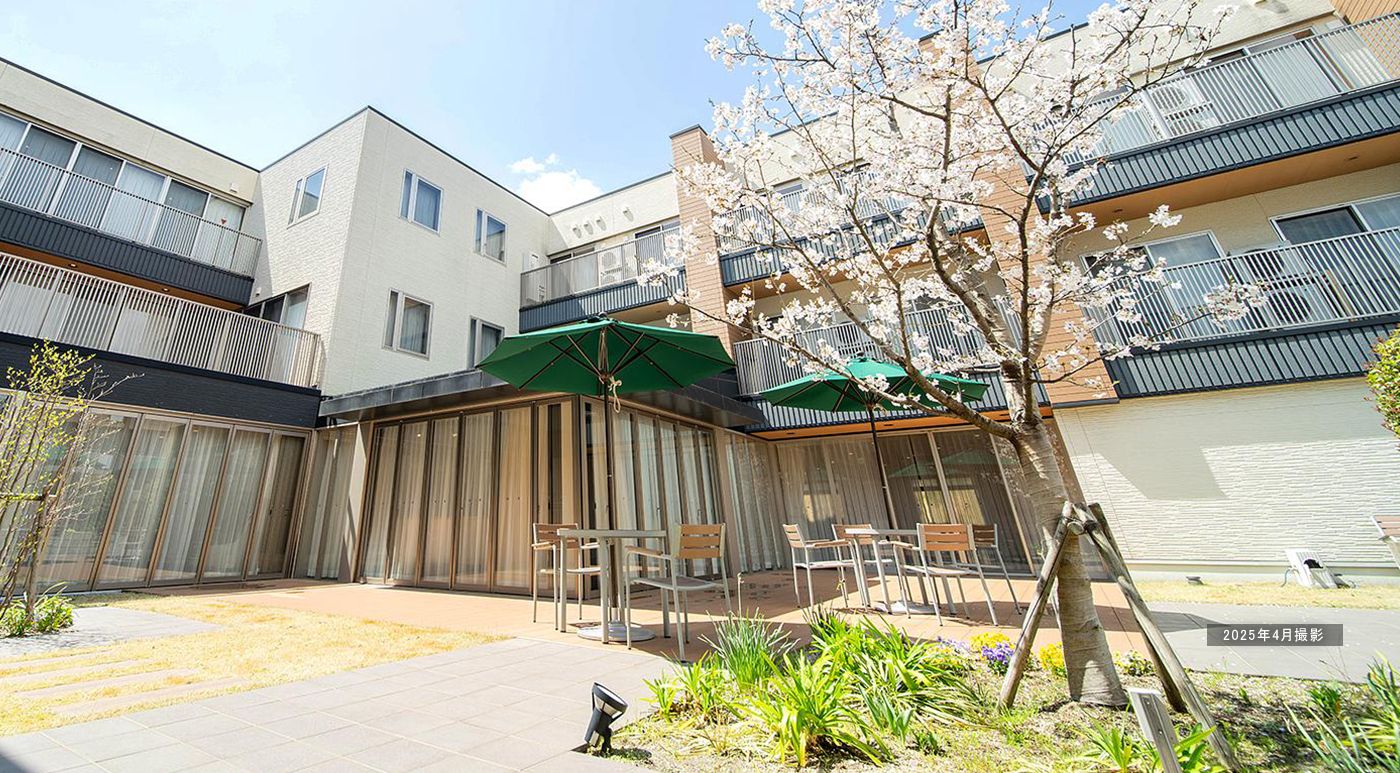 当ホームは３階立て、重厚な造りに落ち着いた色合いの建物で、各部屋にウッドデッキがあり専用駐車場も完備している。