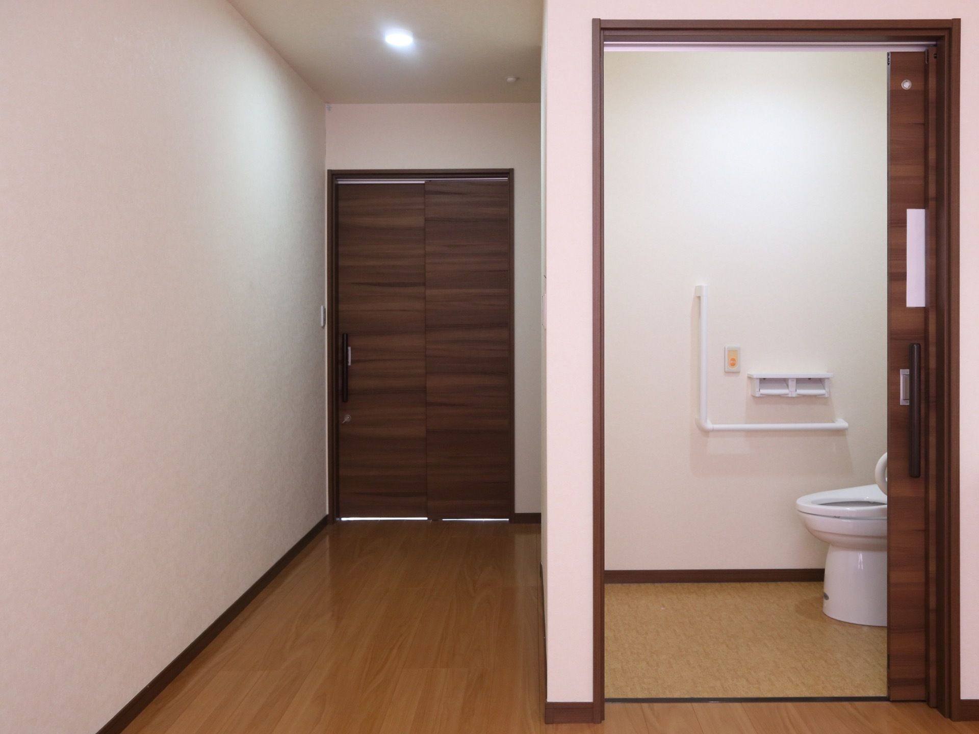 広い間取りの居室には、照明やトイレが完備されている。出入口のドアには、引き戸が採用されている。床はフローリングである。