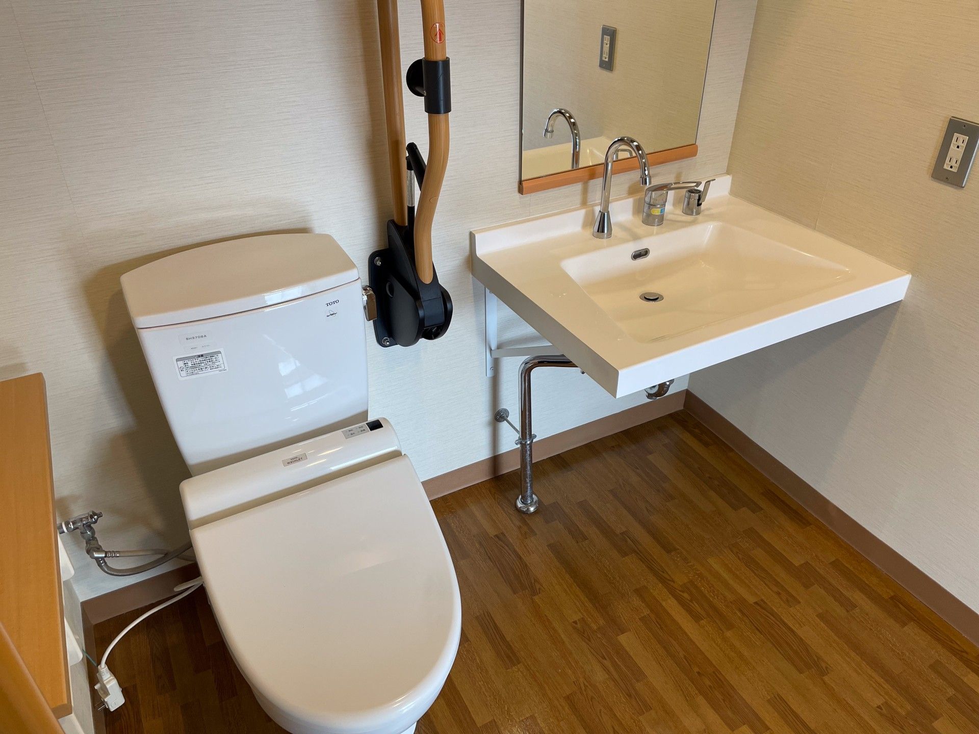 手すり付きのトイレと洗面台