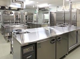 ステンレス製の調理台や流し台、冷蔵庫などが置かれた調理室