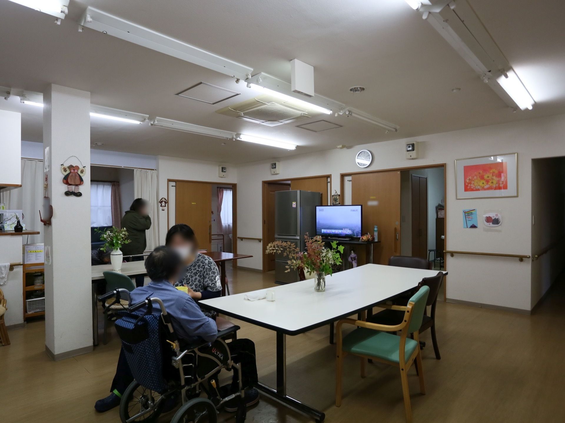 食堂はアットホームな雰囲気である。テーブルには花瓶が飾られ、壁には絵画やあたたかみのある手作りの飾りがある。