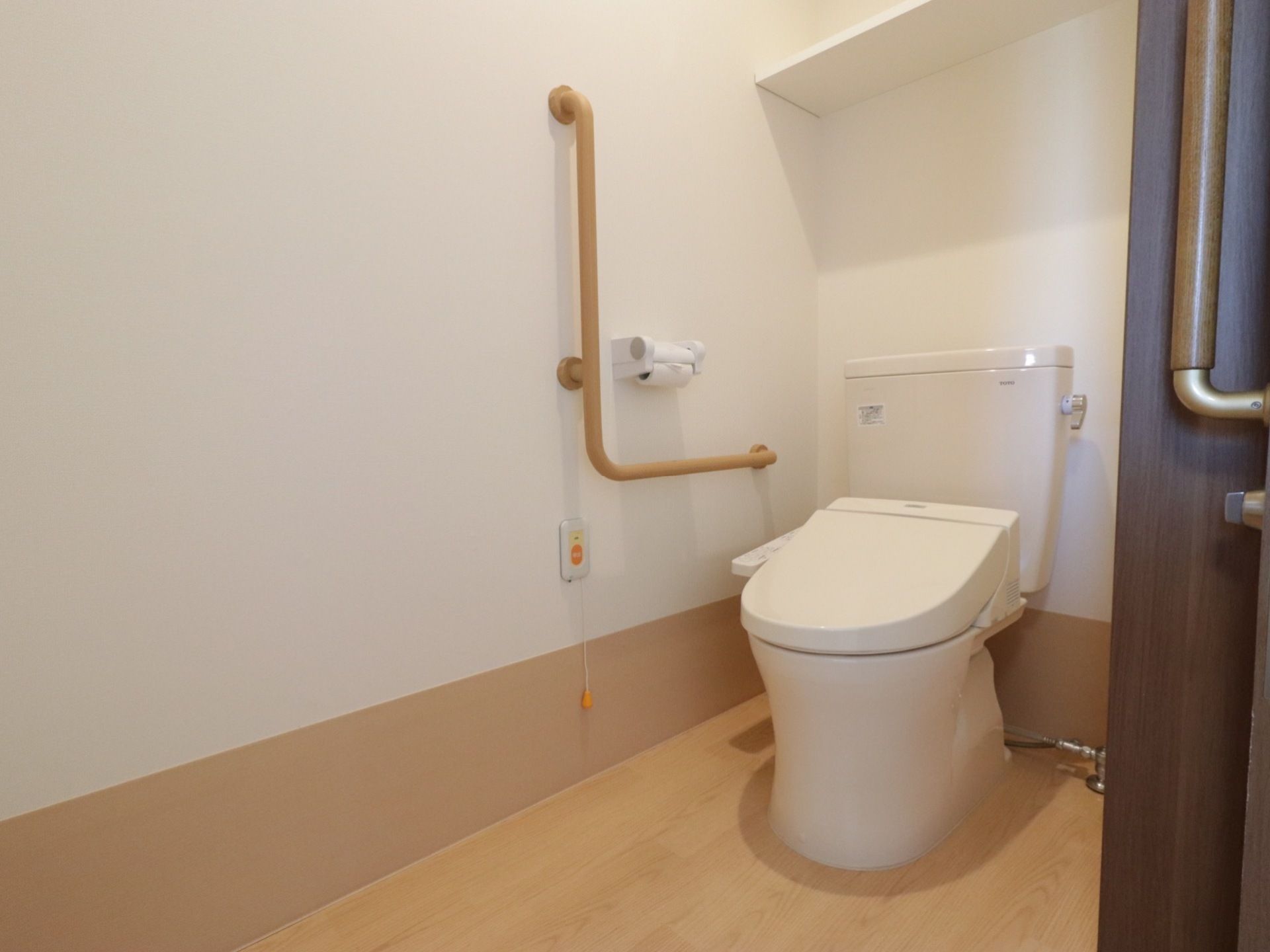 トイレは白を基調にして、清潔感がある。便座横にはL字型に手すりが付いている。ナースコールがあり緊急時にも対応している。