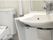 手すりが付いたバリアフリー設計のトイレと洗面台である。白で統一されていて、清掃も隅々まで行き届いている。