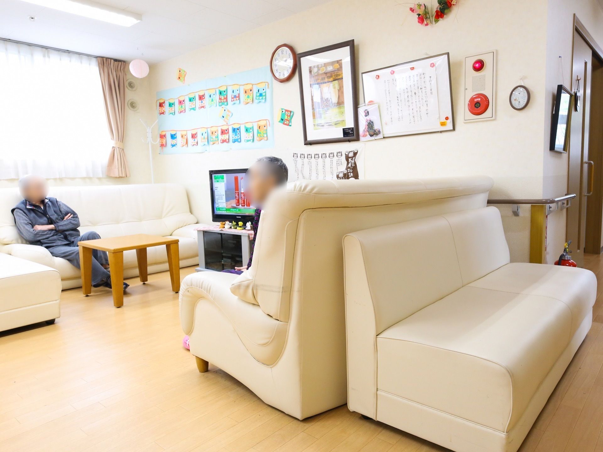 テレビの周りには、ゆったりと座れるソファーが向かい合わせに置いてある。壁の方には、季節を象徴する飾りが貼ってある。