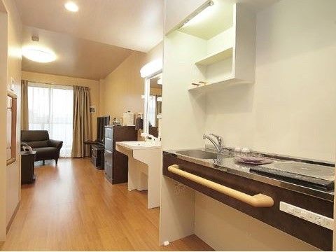 手前から電磁調理器、作業台、シングルレバー水栓の洗い場が並んでいる。台には横長の手すりが付いている。