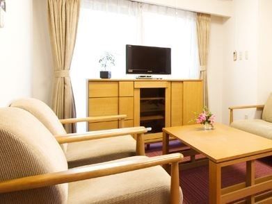 窓際に置かれたチェストの上にテレビが設置され、ソファが置かれた個室
