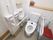 トイレは温水洗浄便座で、壁に操作ボタンが付いている。壁に、小さい手洗い場があり、ペーパータオルも取り付けられている。