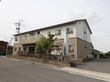 施設の建物は、2階建てである。1階部分は茶色、2階部分は白色の外装をしている。道路側に、掲示板が設置されている。