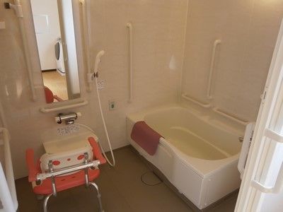 白を基調とした個室タイプのシンプルな浴室である。壁には複数の手すりと呼び出しボタンが設置されている。