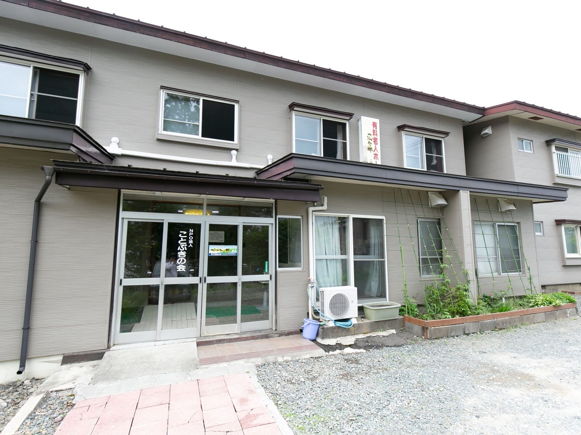 2階建ての建物で、玄関前にはゆるやかなスロープが設置してある。玄関隣の家庭菜園では野菜を栽培している。