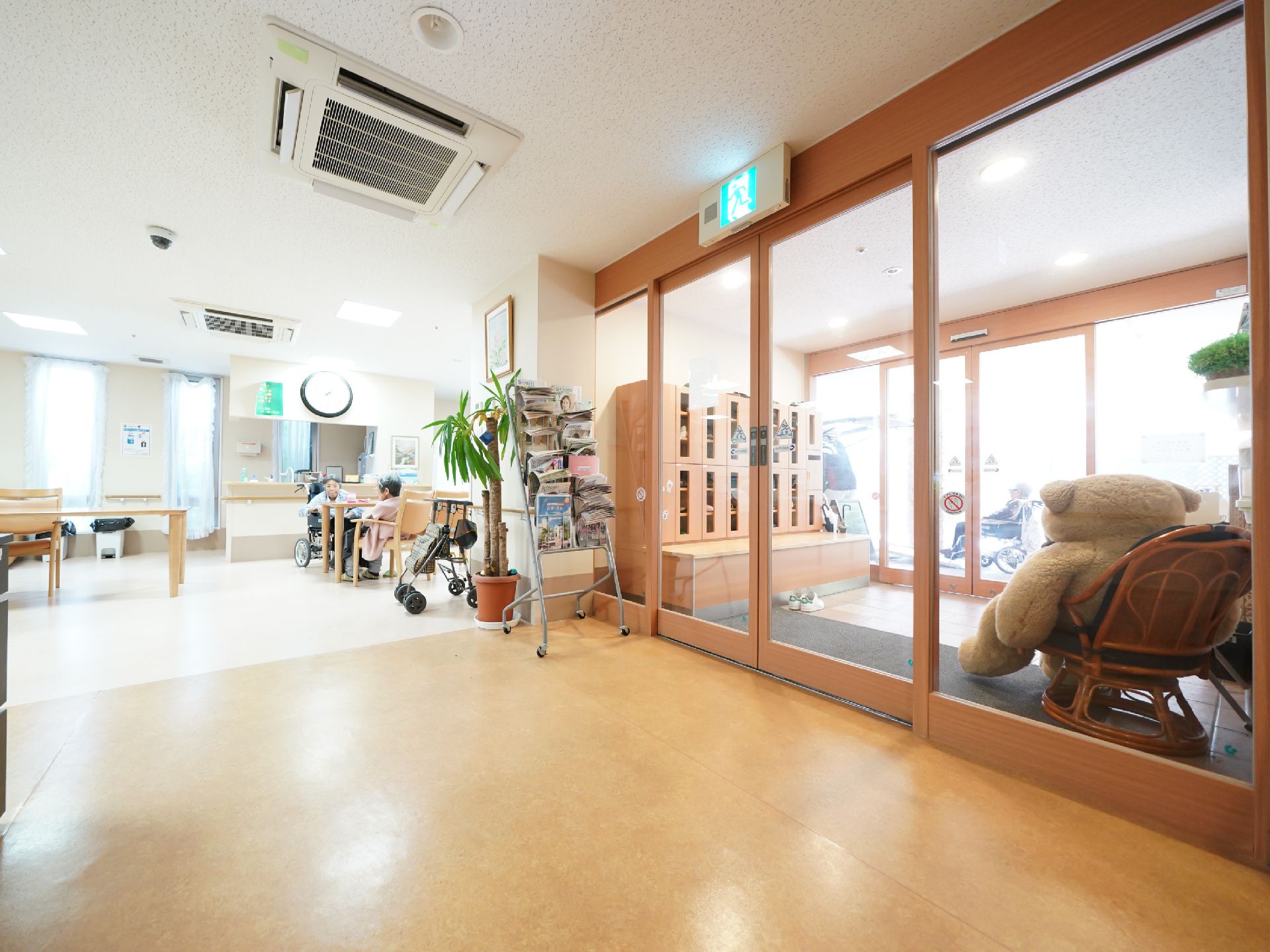 巨大なクマのぬいぐるみが置かれた二重の自動ドアのエントランス