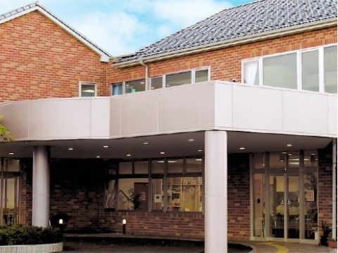 外壁がレンガ風の建物で、玄関前がピロティになっている施設