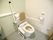 温水洗浄便座付きの洋式トイレが設置され、背あてと可動式のひじ掛けが追加されている。壁にはナースコールが付いている。