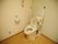 温水洗浄便座付きの洋式トイレが設置され、左右には可動式のひじ掛けが付いている。横の壁にはトイレの操作ボタン、ナースコールが付いている。