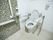 床はフローリングで、洋式トイレがある。温水洗浄機がついていて、シートの横に操作部が取り付けてある。壁に手すりがある。