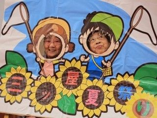 施設のイベントで、手作りの顔出しパネルから顔を出す入居者たち