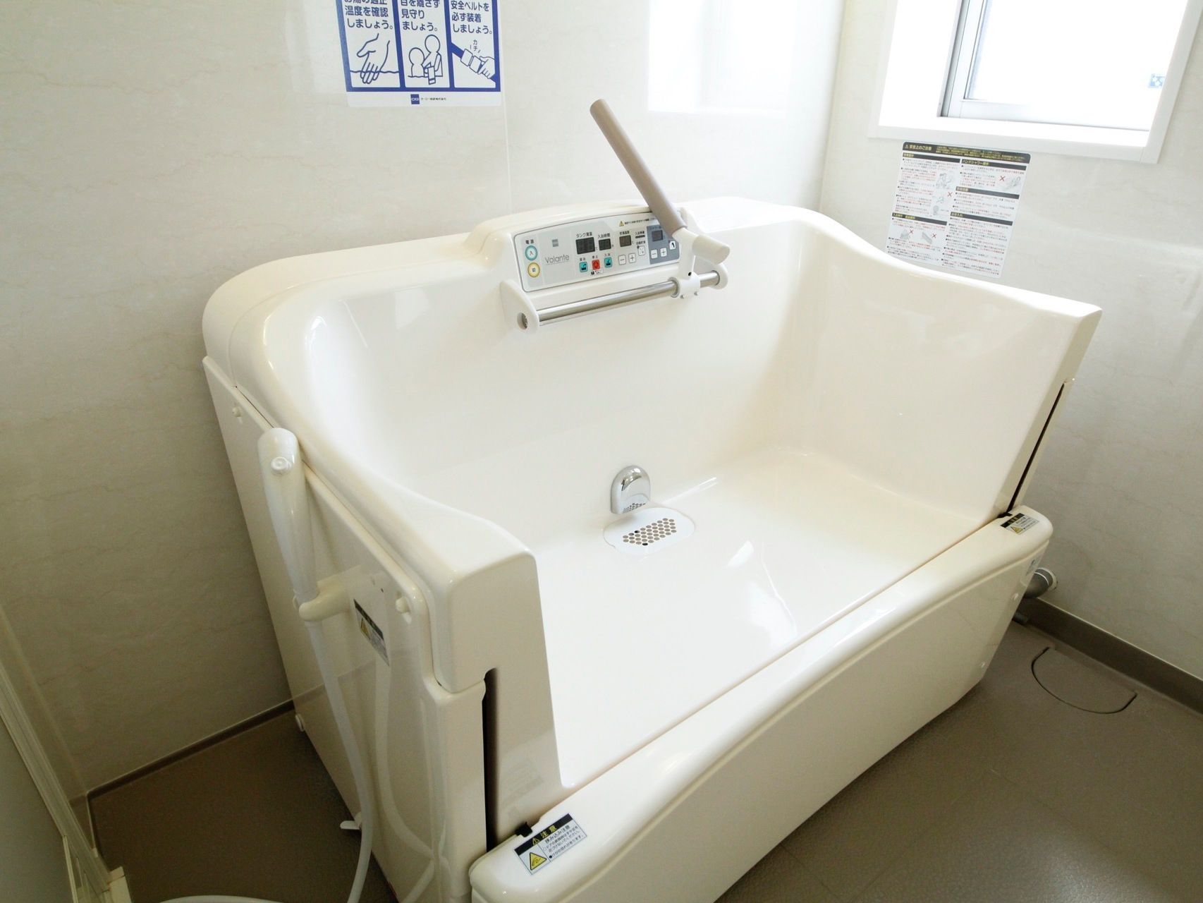 明るいベージュ系で統一された浴室には介護度の高い方も座ったままの体勢で入浴ができる機械浴槽が置かれている。