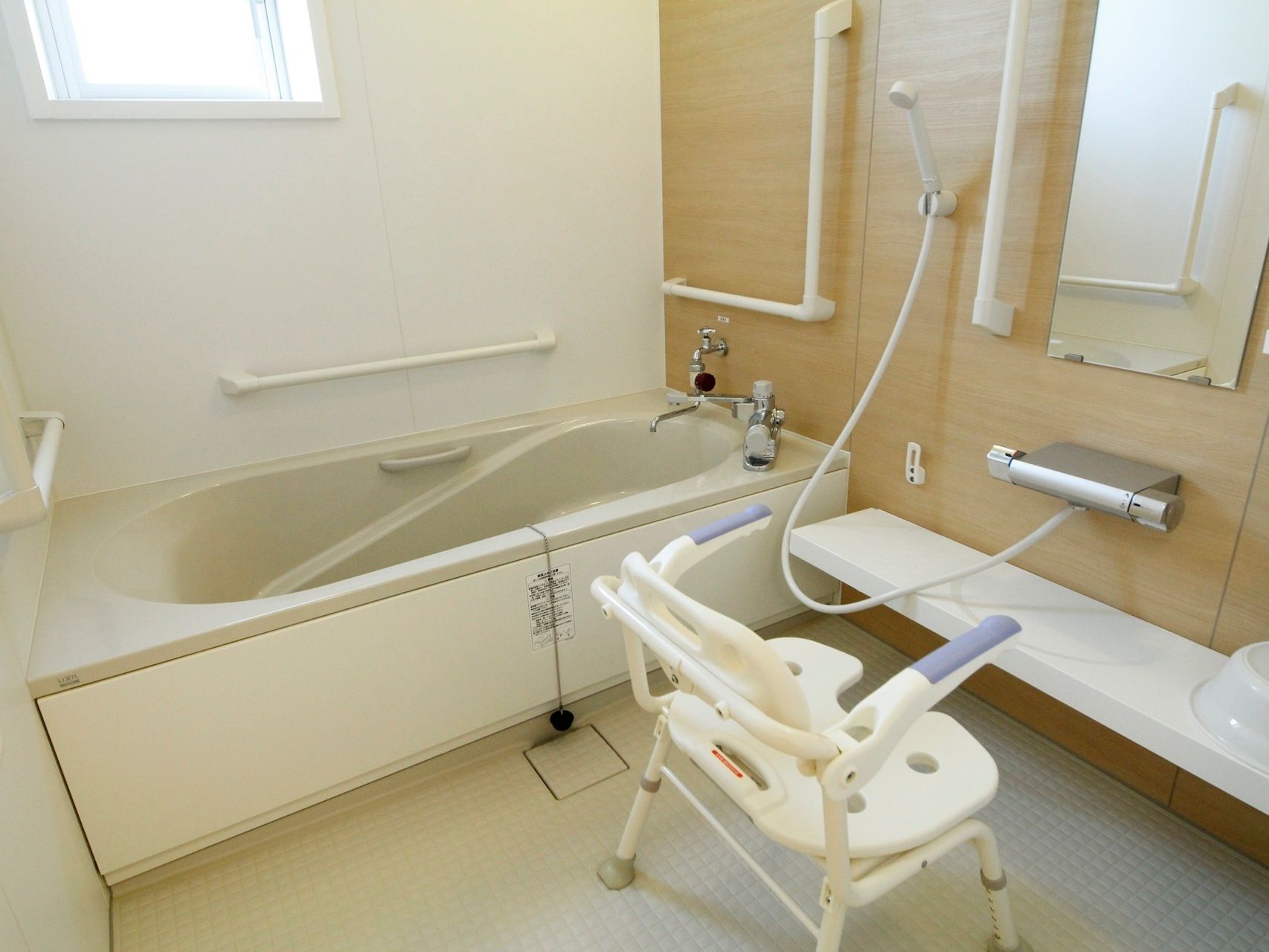 居室に用意された個人用の浴室。壁にはＬ字や縦横の手すりが取り付けられ、入浴などの行為の際に体の支えとなる。