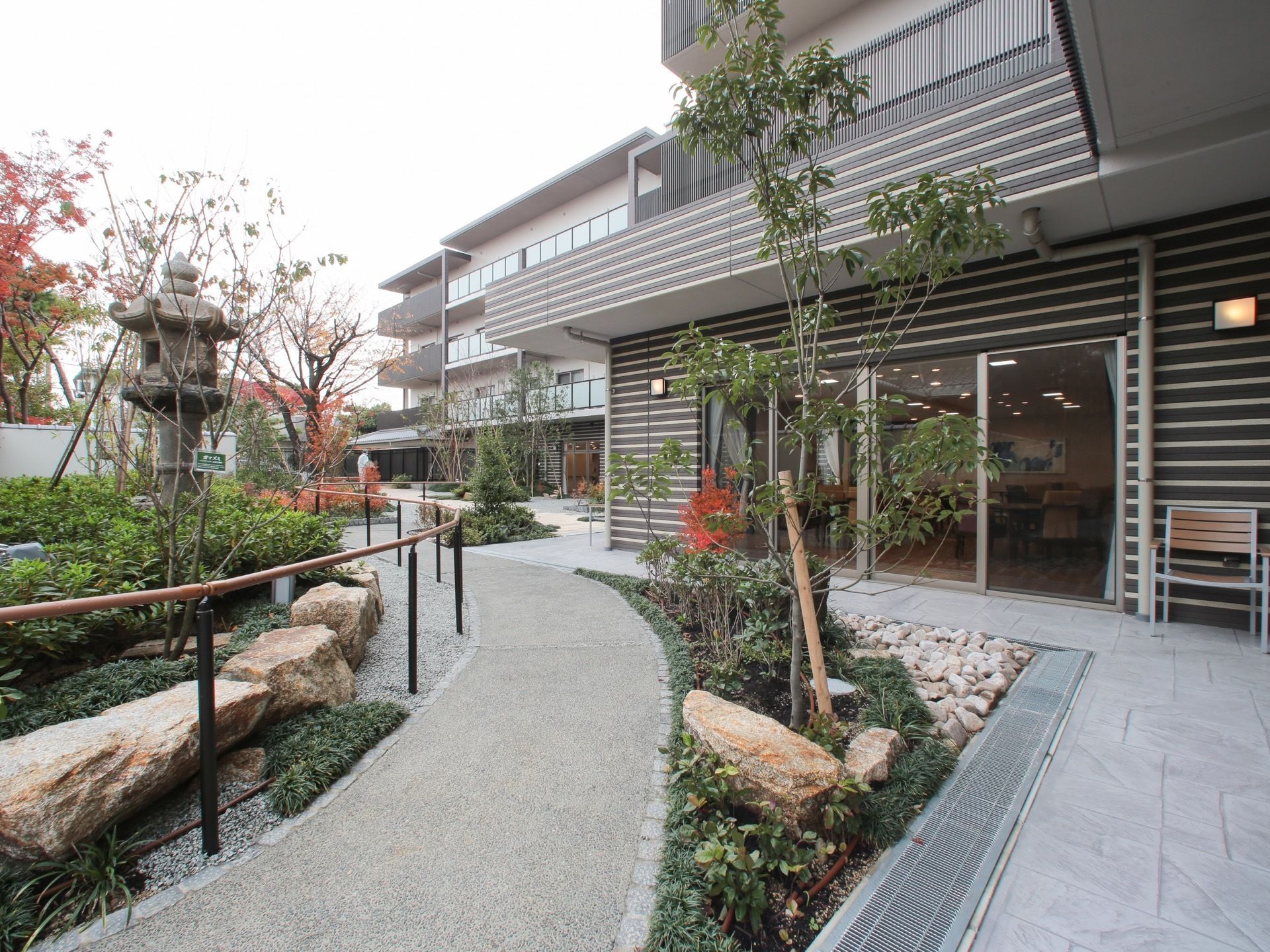 建物の外の和風な庭に伸びる、様々な植物を眺めながら歩くことのできる遊歩道