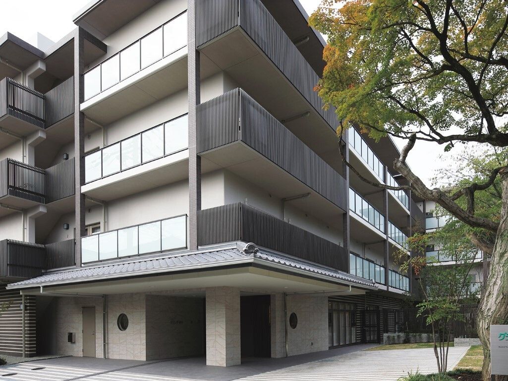 広い敷地の中に建つ、４階建ての外階段を備えた施設の外観