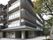 広い敷地の中に建つ、４階建ての外階段を備えた施設の外観