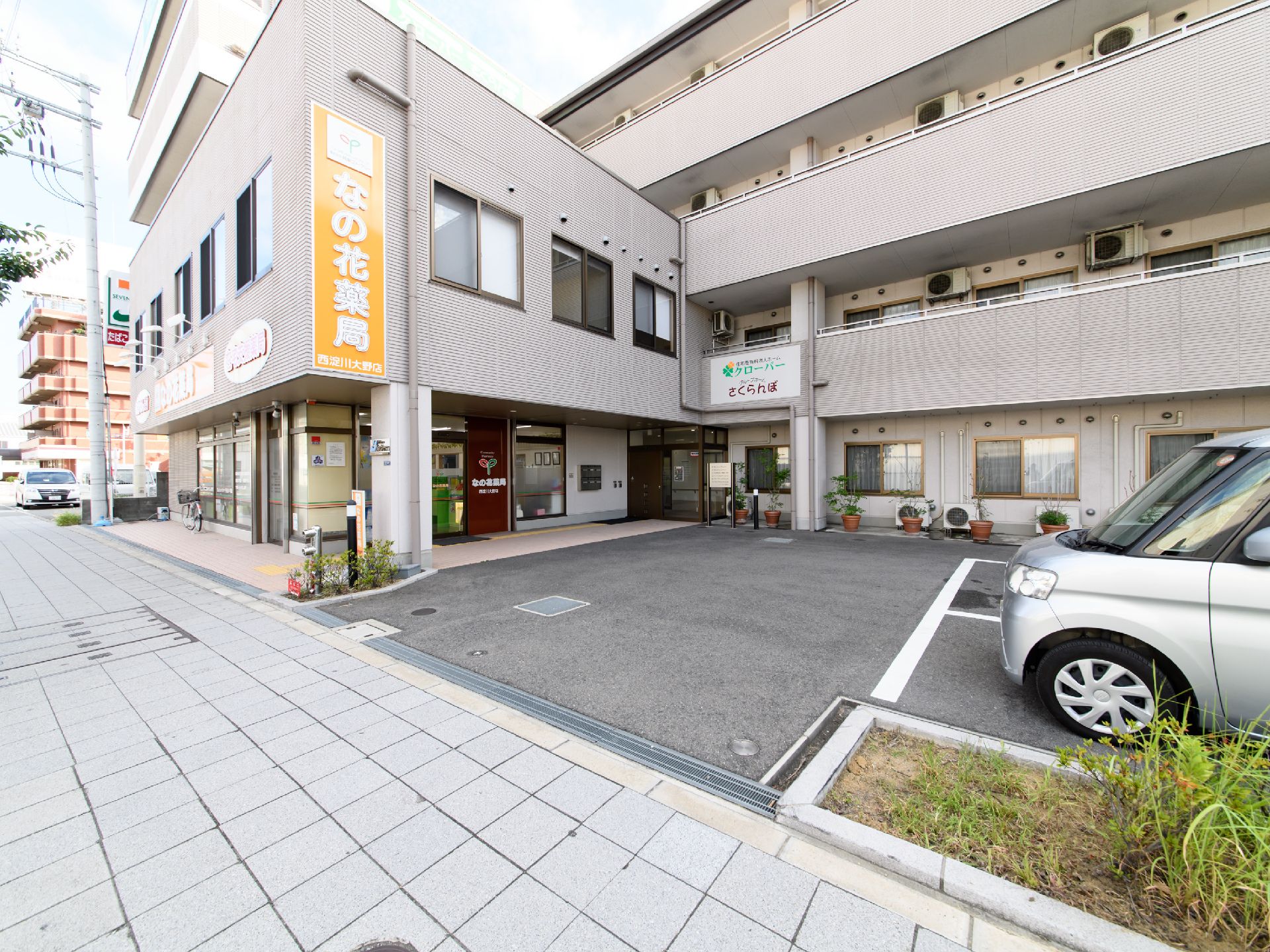 薄いグレイ色の外観のエル型構造の4階建ての建物である。薬局などと併用され、敷地内には車を停めることができるスペースがある。
