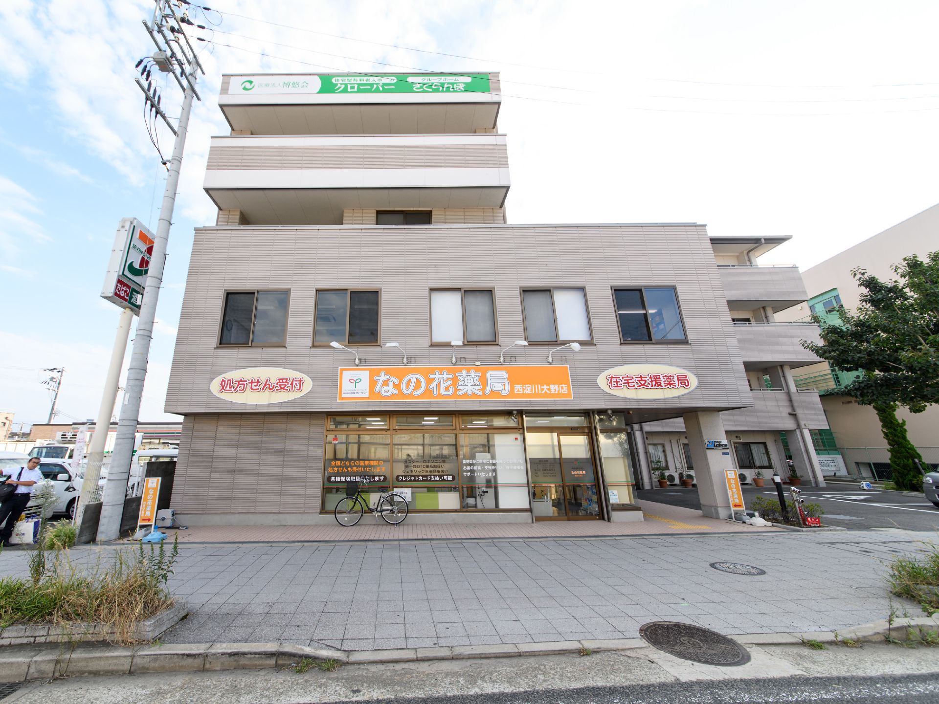 道路に面した1階部分に薬局が併設された駐車場付きの4階建ての施設