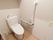 トイレの個室内は白色の壁、淡い茶色の床面である。壁にはL字型の手すりや緊急時呼び出しブザーが備わっている。