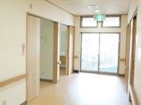 廊下には十分な広さの幅があり、安全性が確保されている。壁には手すりが設けられ、引き戸によって部屋が区切られている。