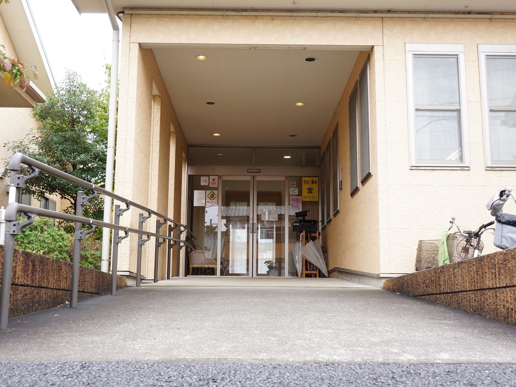 自動ドアの前に傘立てがある。中に入ると椅子が置かれ一息つける様になっている。防犯カメラが設置されている。