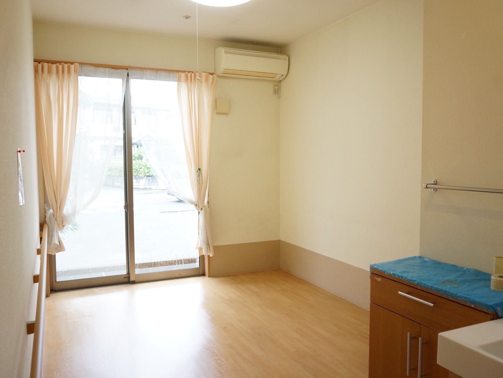 大きな窓があり室内を明るくしている。エアコンは設置されていて快適な温度で過ごす事が出来る。壁には手すりがある。