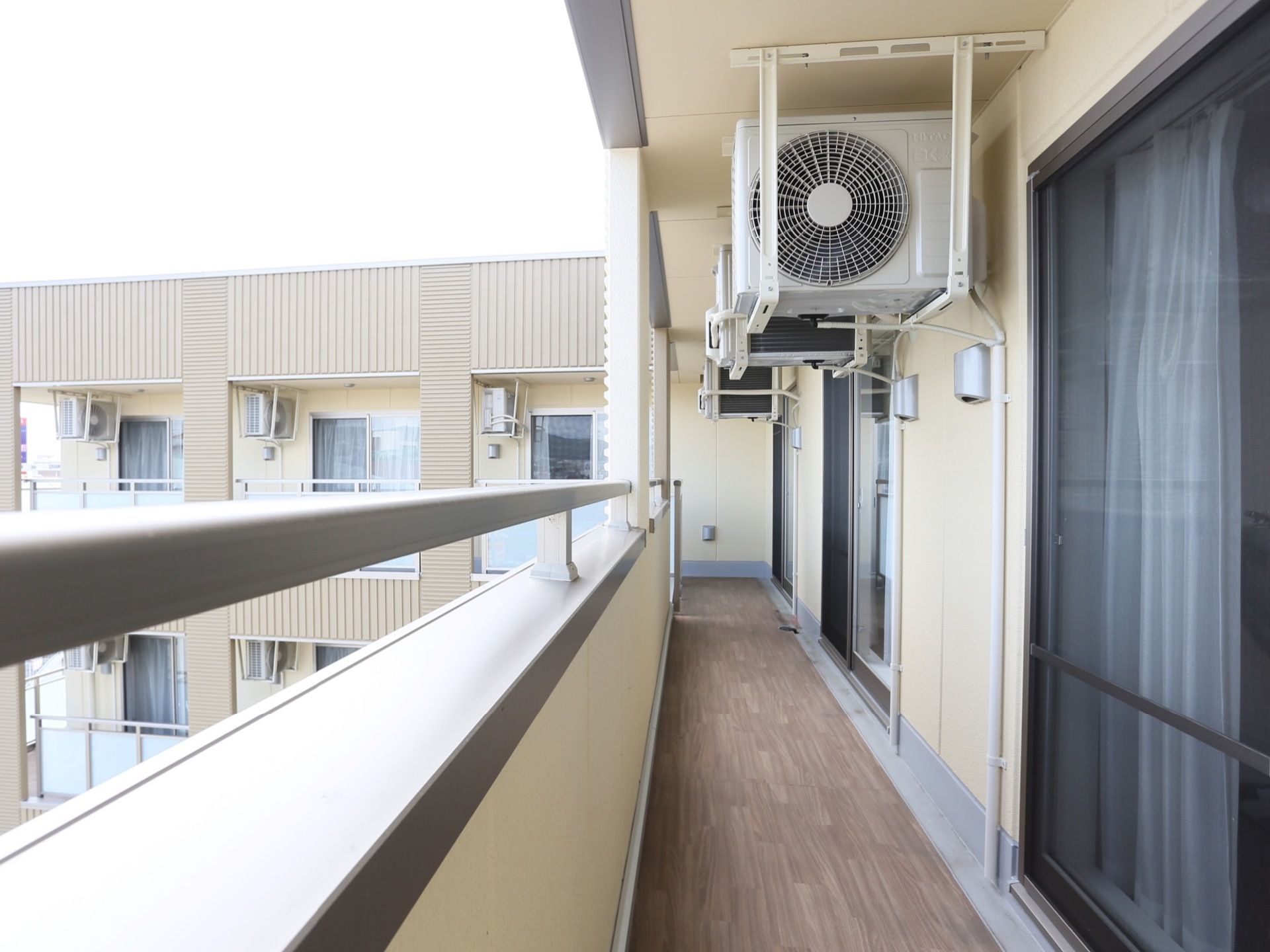 居室についているベランダで、隣の部屋とつながっている。床は木目調になっており、洗濯物を干すことができる。