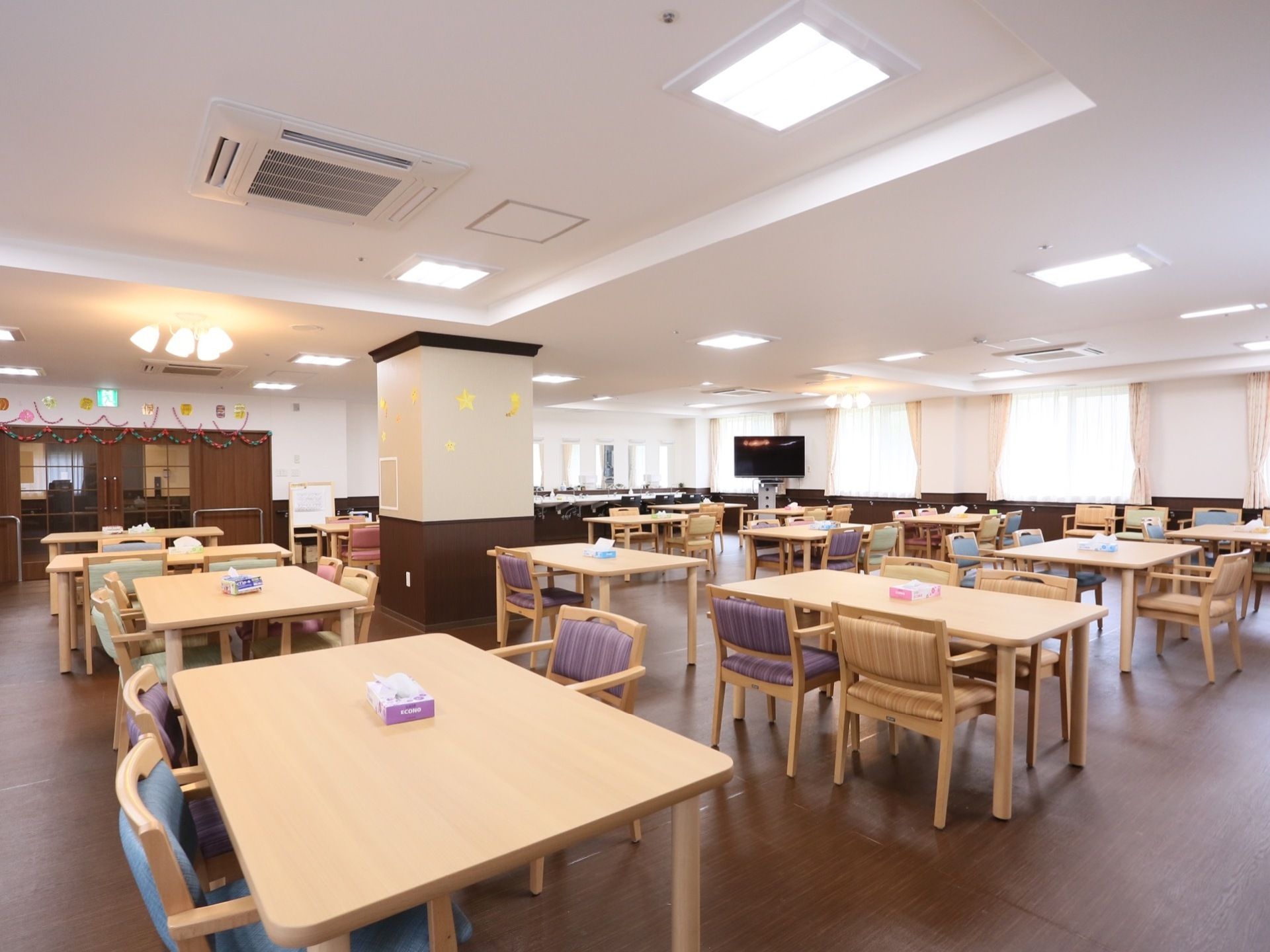 開放感のある広い食堂。室内は制作物などで飾りつけられており、どの席からも見える位置にテレビが設置されている。