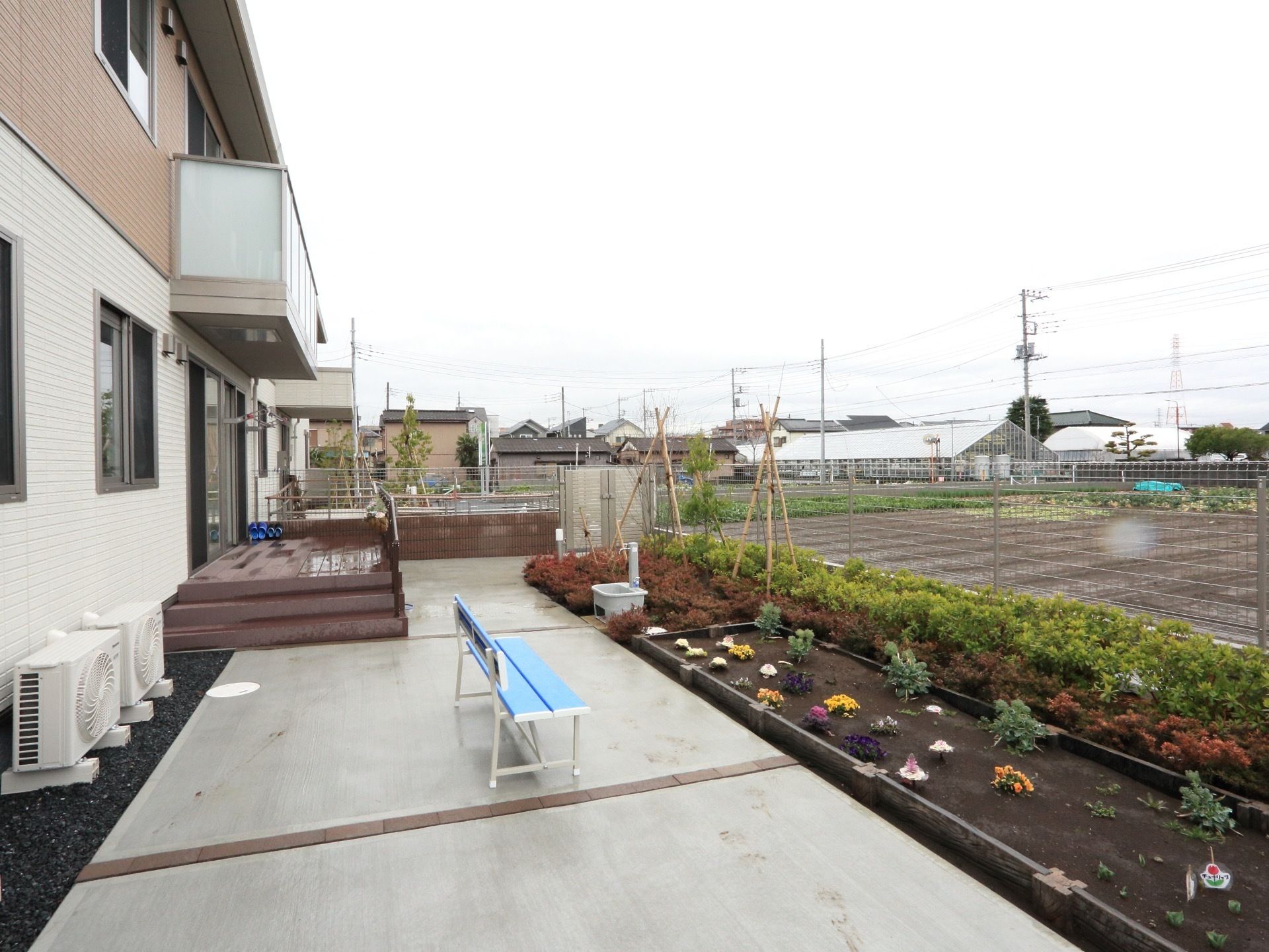 一階の窓に設けられたウッドデッキから階段を下りると、花壇やベンチが設置されたスペースへ出ることができる。