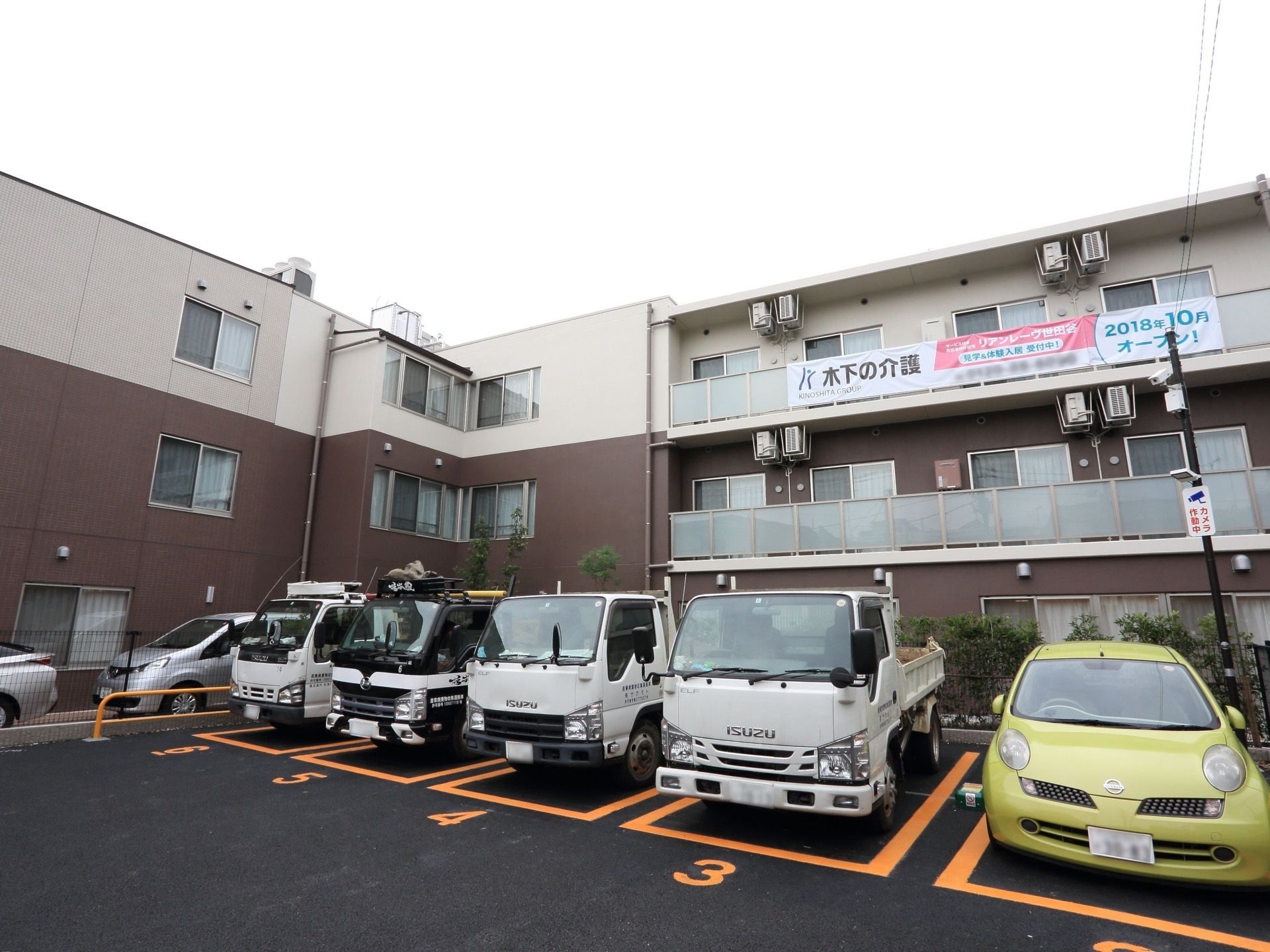 白と茶色の２色にデザインされた、３階建ての施設である。建物の前にはナンバーが記された、有料駐車場が完備されている。