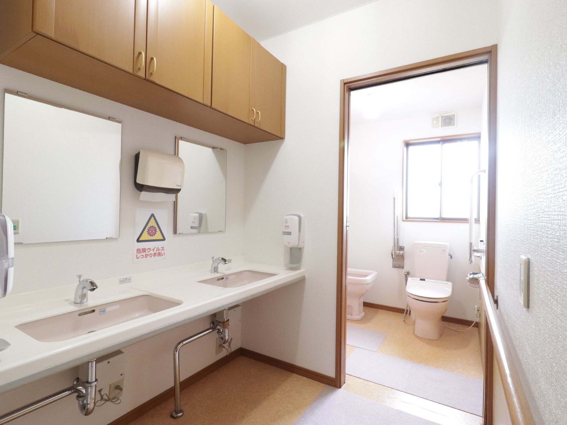 共同のトイレは、洋室で幅広く車椅子でも出入りができる。洗面台が二基とりつけてあるので、混雑せずに済む。