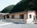 一階建ての施設の裏には緑がふんだんにあり、自然を感じて過ごすことができる。玄関にはスロープもあるので車椅子でもスムーズに来館できる。