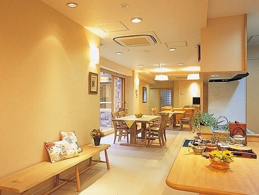 鮮やかな水色の海を背後に並び記念撮影をする高齢者と職員
