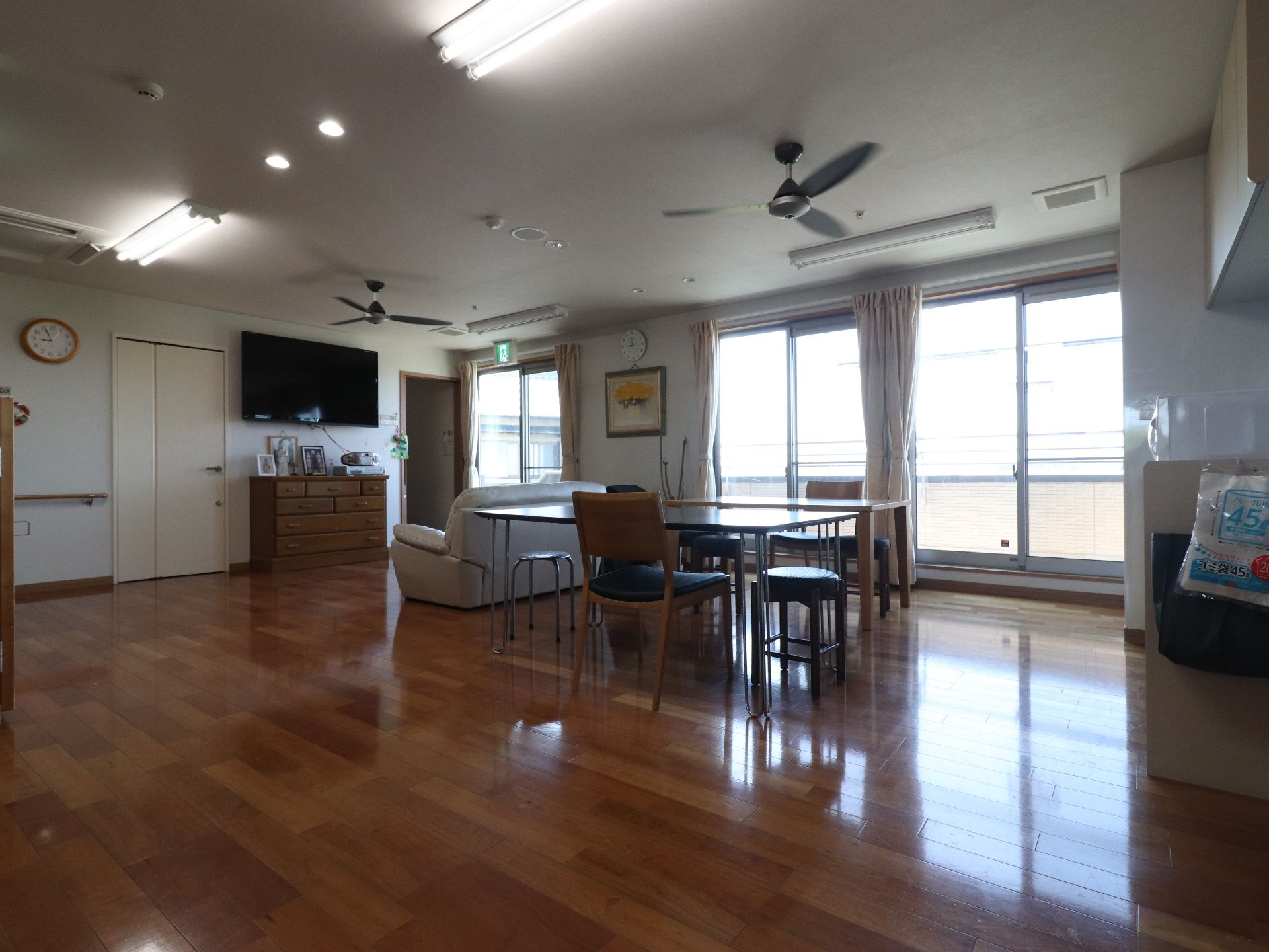 2階フロアは広々としており、テーブルやいす、ソファーなどが設置されている。奥にはテレビと小さなたんすが設置されている。