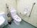トイレの壁紙は薄い地に白で花柄が描かれている。トイレタンクの上にはトイレットペーパーが4つ置かれている。