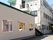 白い外壁と緑の屋根の３階建ての建物があり、その横に平屋の建物が並んでいる。３階建ての建物の壁に施設の名前が掲げられている。