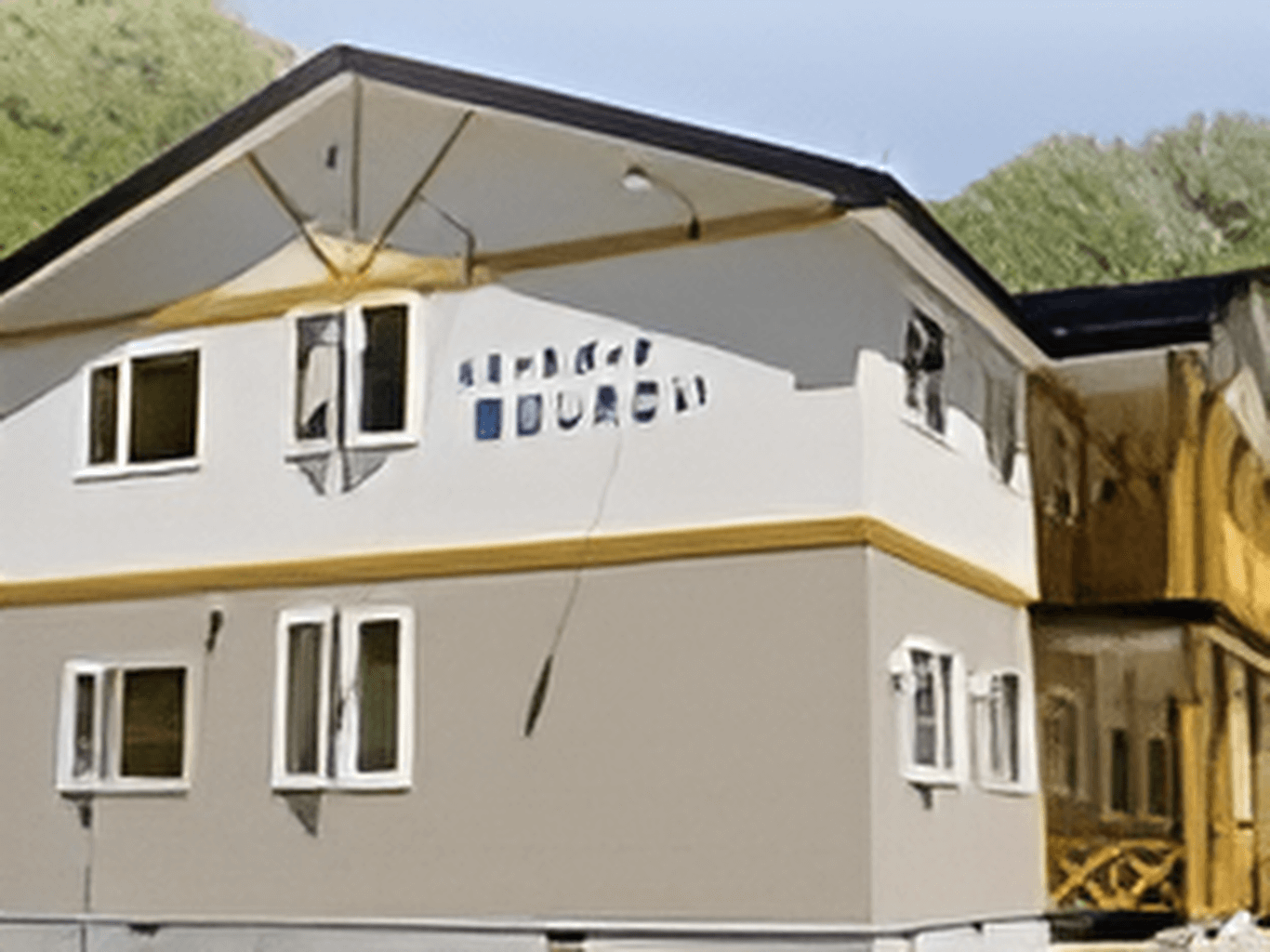 グレーと白のツートンカラーを採用したスタイリッシュな建物。近くには大きな木々があり、四季の変化が楽しめる。