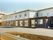 白と茶色の二階建ての建物である。駐車場も完備しており、ご家族様が来訪の際も便利である。快適な生活を送っていただける環境である。