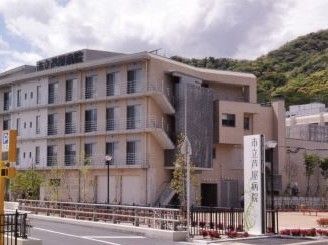 近隣にある医療機関の外観である。病院の建物は4階建てである。病院の前を通る道路と歩道の間には柵が設けられている。