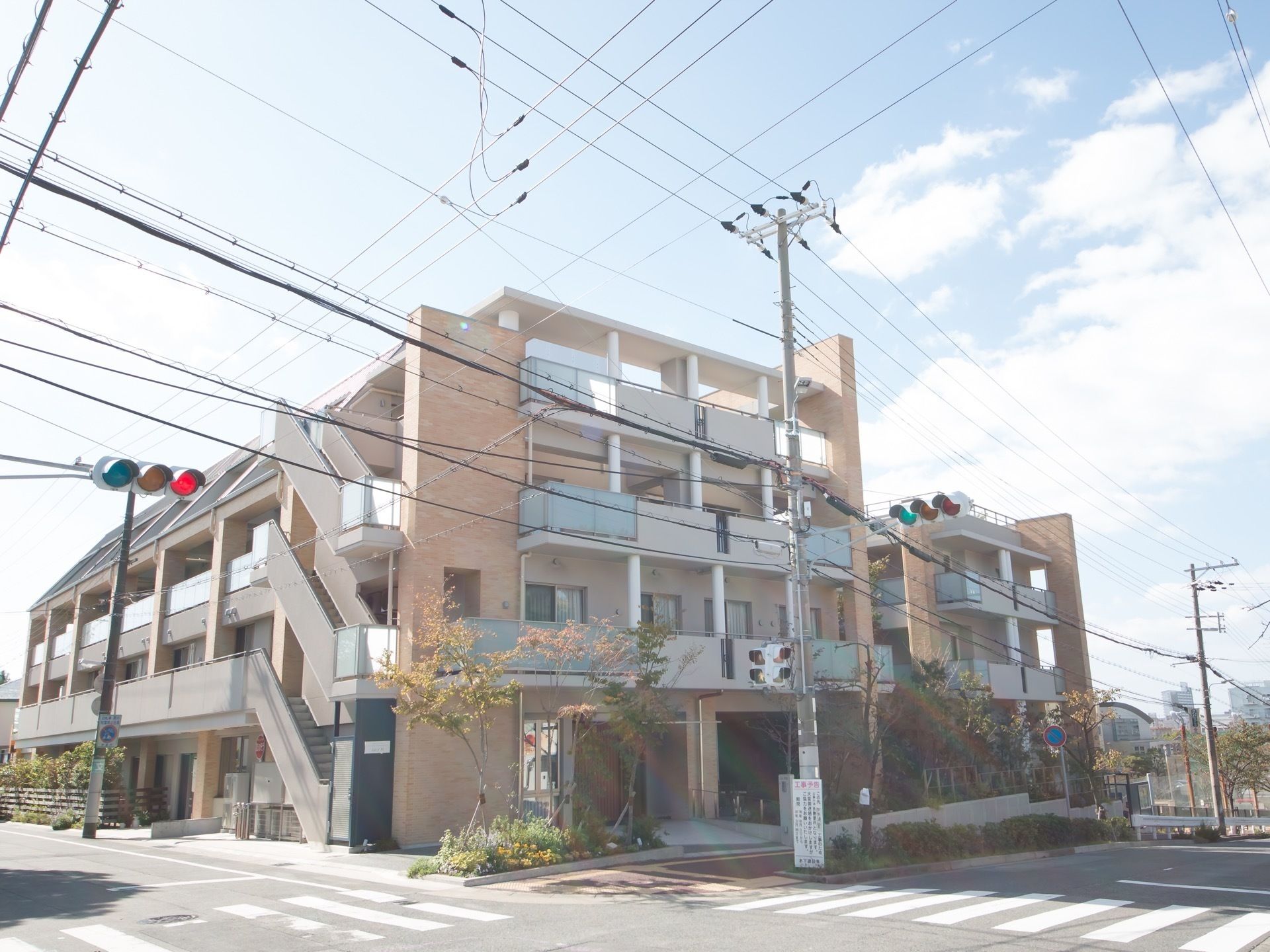 大通りに面した交差点に建つ、外階段付きの四階建ての建物