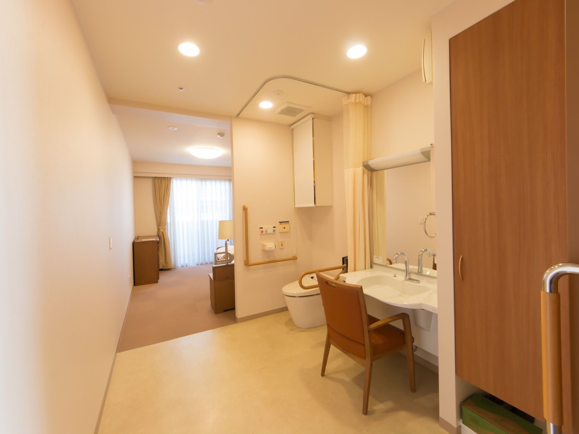 居室は白を基調とした内装で、洗面スペースやトイレも室内に完備されている。奥には、ベランダスペースも設けられている。